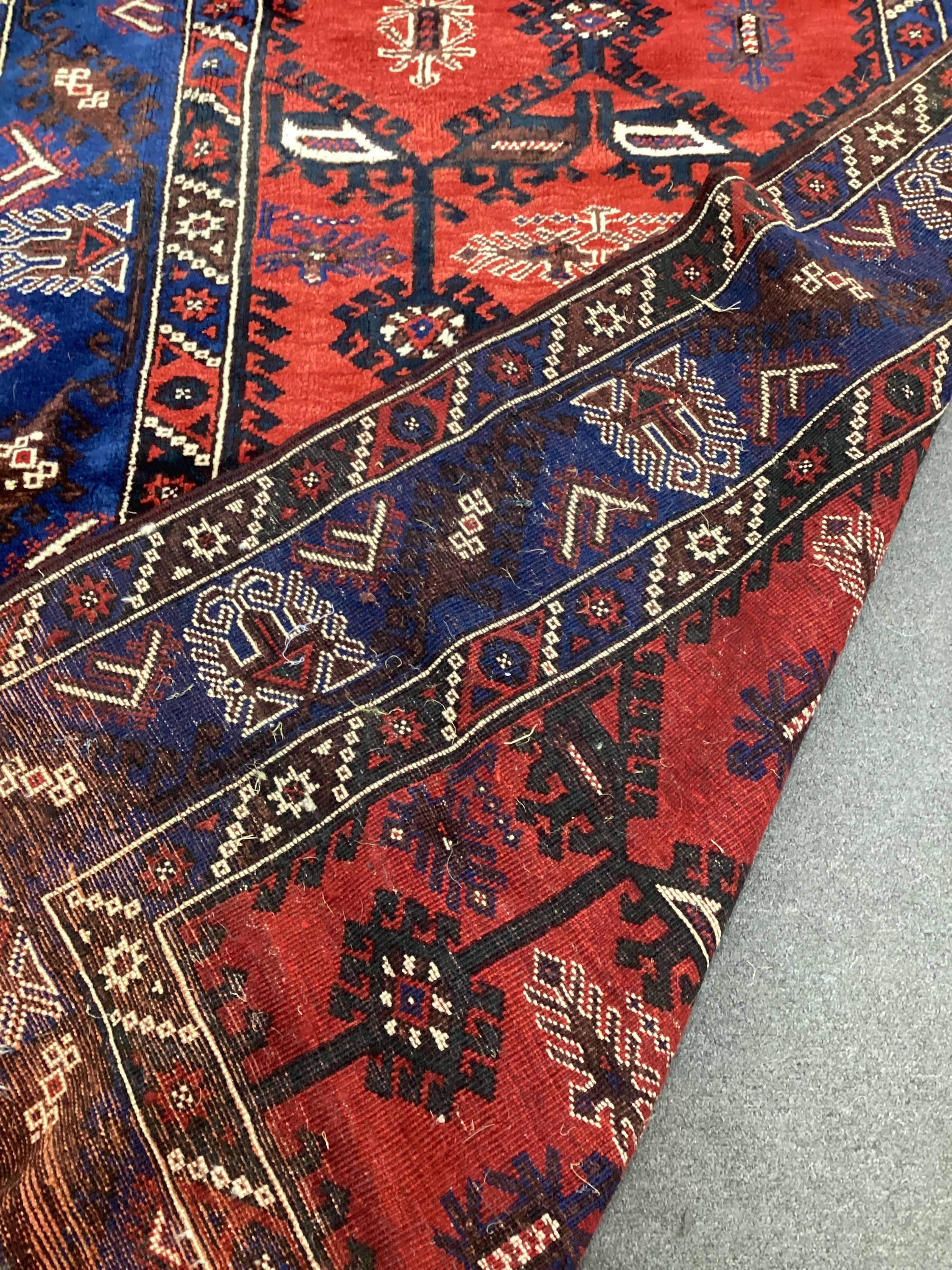A Caucasian style red ground rug, 220cm x 140cm